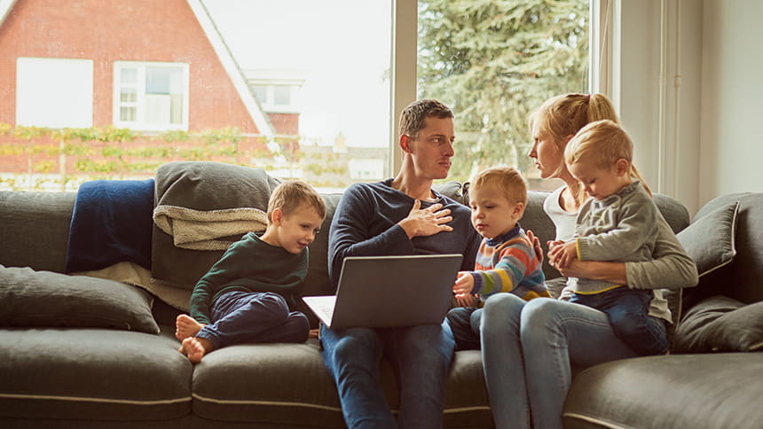 Familien samlet om computeren i sofaen