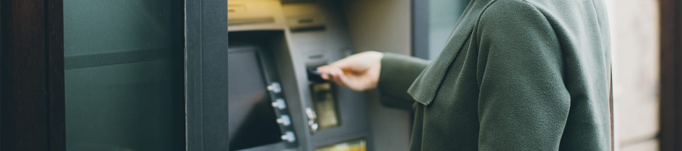 Kvinde der stikker sit kort i en automat