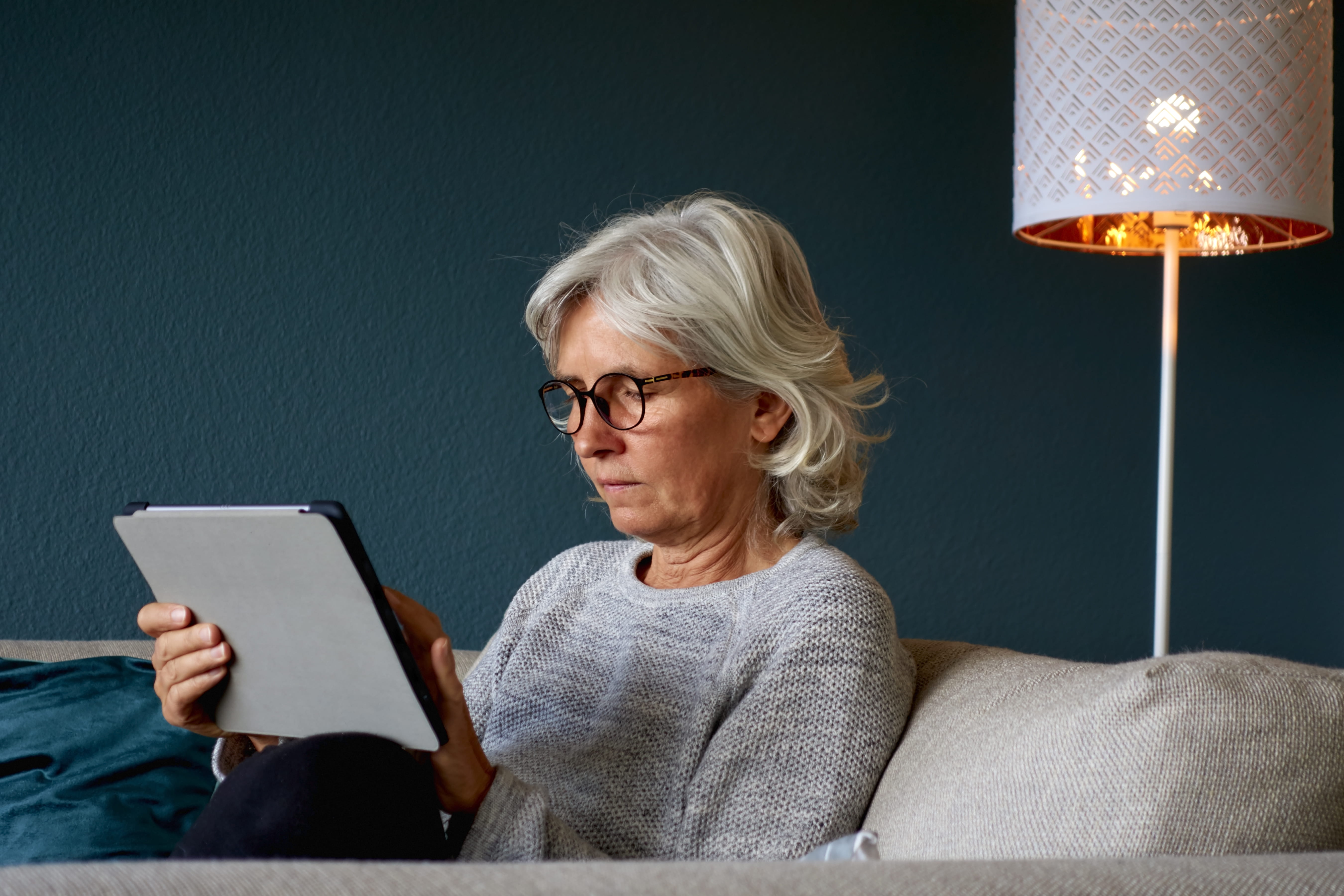 Kvinde der sidder med sin tablet 