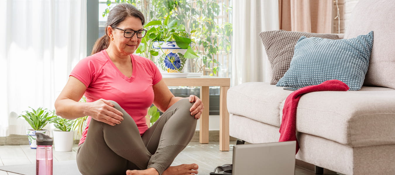 Kvinde sidder på gulvet i træningstøj