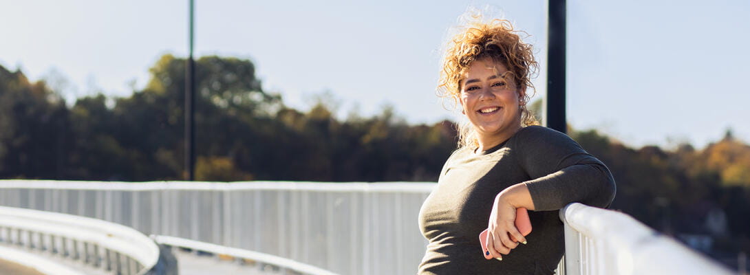 Yngre kvinde kigger glad ind i kameraet