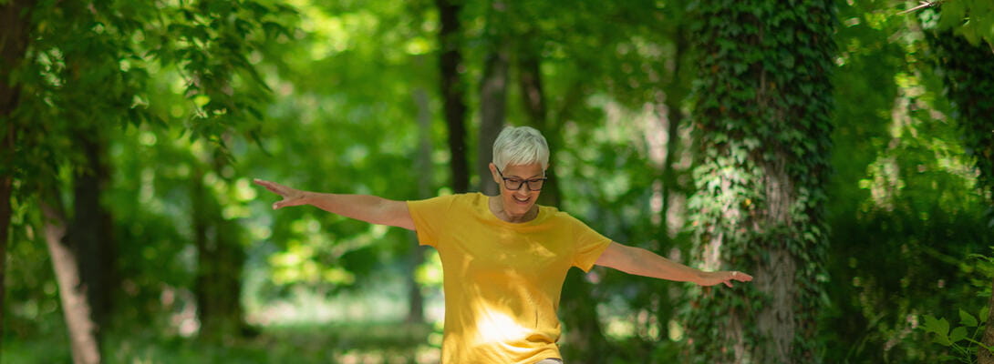 En glad kvinder balancerer i naturen